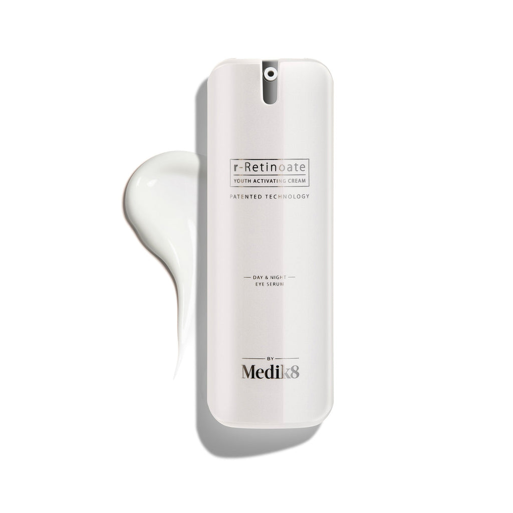 Eine weiße Pumpflasche mit r-Retinoate Day & Night Eye Serum und einem Tropfen Produkt daneben.