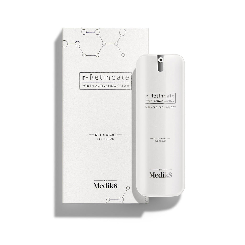 Eine weiße Pumpflasche mit r-Retinoate Day & Night Eye Serum steht neben dem passenden weißen Karton.
