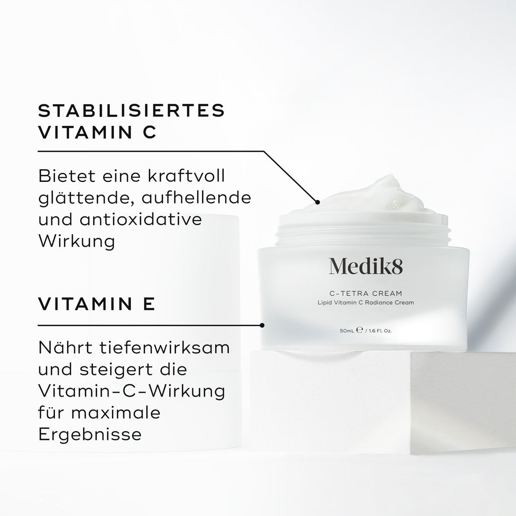 Medik8 C-Tetra Cream Tiegel geöffnet auf einem weißen Steinblock vor einem klaren weißen Hintergrund präsentiert. Das Bild zeigt zwei Hauptinhaltsstoffe und ihre Vorteile:

STABILISIERTES VITAMIN C: Sorgt für kraftvolle glättende, aufhellende und antioxidative Vorteile.

VITAMIN E: Nährt intensiv und verstärkt die Wirkung von Vitamin C für maximale Ergebnisse.